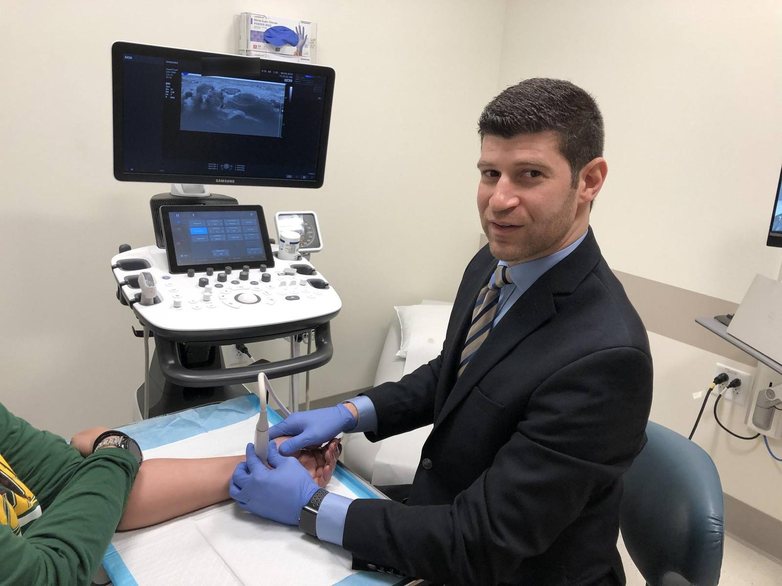 Dr. Goldwaser using ultrasound to examine a patient’s forearm